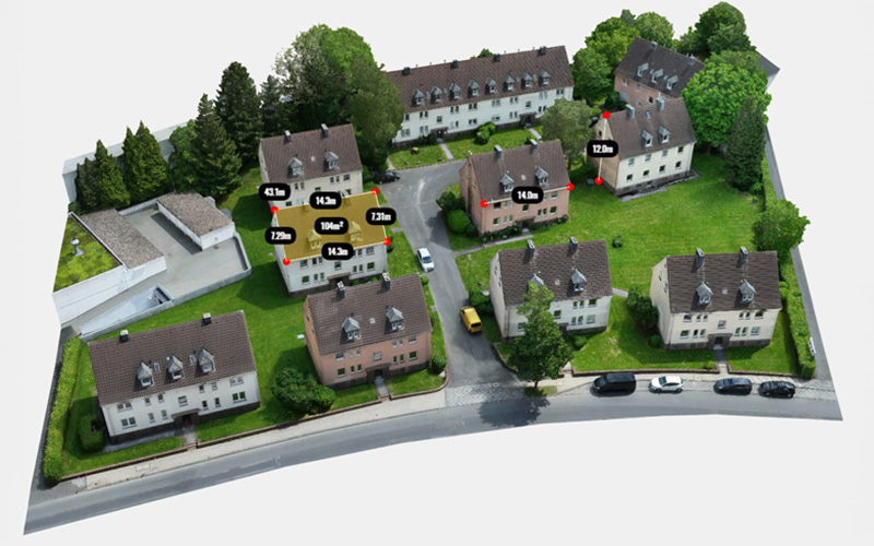 3D-Drohnenvermessung von Gebäuden und Grünflächen für effizientes Facilitymanagement 3D-Drohnenaufnahme einer Wohnsiedlung mit visualisierten Flächen- und Höhenmessungen für Gebäude, Dächer und Grünflächen zur präzisen Liegenschafts- und Facilitymanagement-Planung